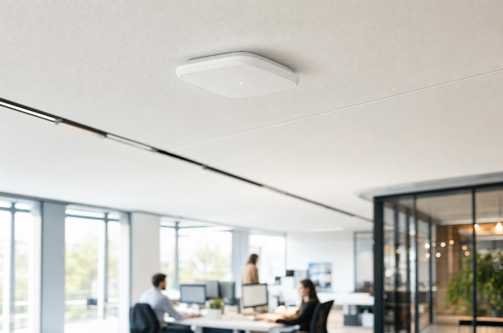 A ceiling-mounted access point in a bright office